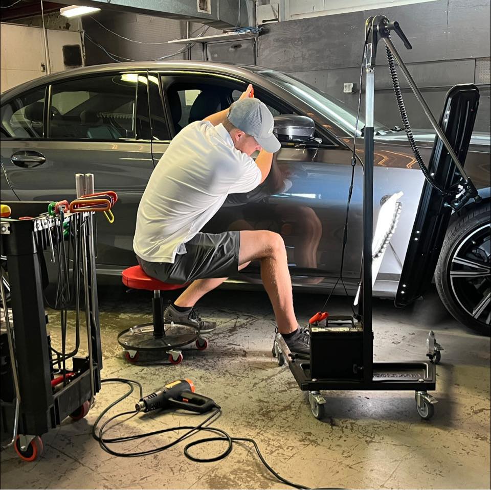 Technician performing paintless dent removal.
