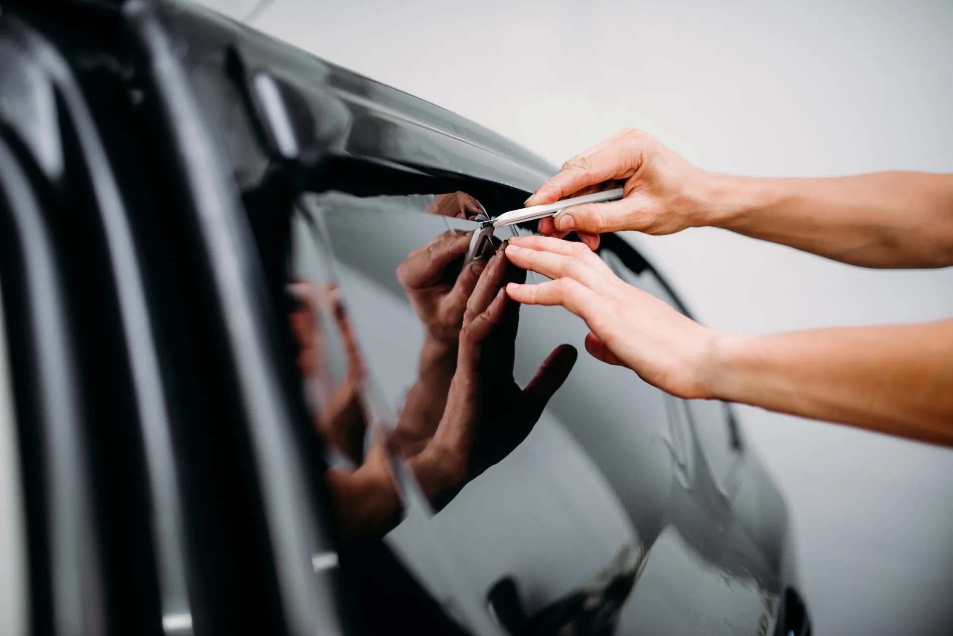 Technician putting on window tint.